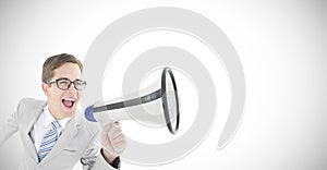 Composite image of geeky businessman shouting through megaphone