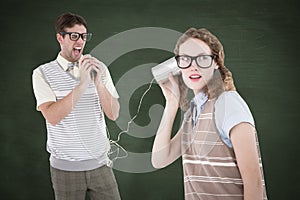 A Composite image of geeky hipster couple speaking with tin can phone