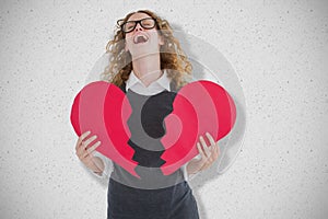 Composite image of geeky hipster holding a broken heart card