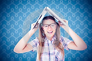 Composite image of geeky hipster holding her laptop over her head