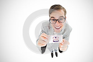 Composite image of geeky hipster smiling and showing card