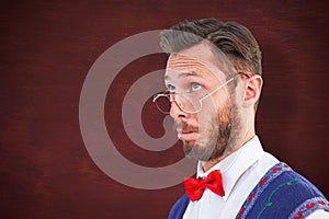 Composite image of geeky hipster wearing christmas vest