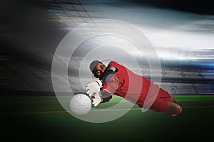 Composite image of goalkeeper in red making a save