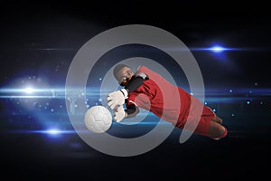 Composite image of goalkeeper in red making a save