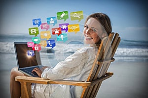 Composite image of gorgeous blonde sitting on deck chair using laptop on beach 3d