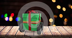 Composite image of green gift box with wheels