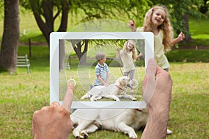 Composite image of hand holding tablet pc