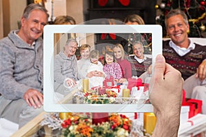 Composite image of hand holding tablet pc