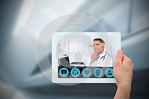 Composite image of hand holding tablet pc