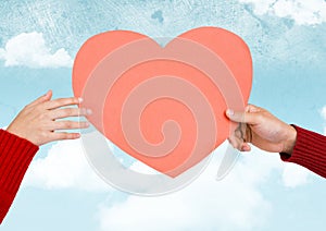 Composite image of hands holding a pink heart