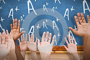 Composite image of hands raising in the air