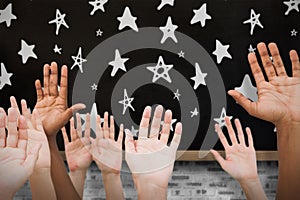 Composite image of hands raising in the air