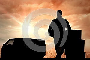 Composite image of handsome delivery man leaning on stacked cardboard boxes