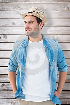 Composite image of handsome hipster wearing a trilby