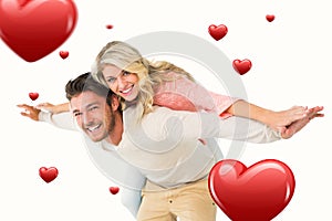 Composite image of handsome man giving piggy back to his girlfriend