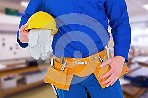 Composite image of handyman holding helmet