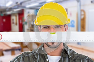 Composite image of handyman looking at spirit level