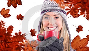 Composite image of happy blonde in winter clothes holding mug