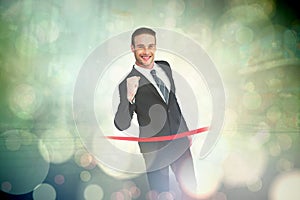 Composite image of happy businessman crossing the finish line