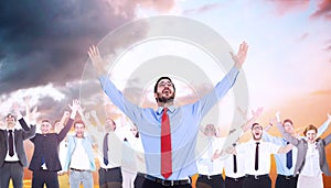 Composite image of happy cheering businessman raising his arms