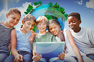 Composite image of happy children using digital tablet at park