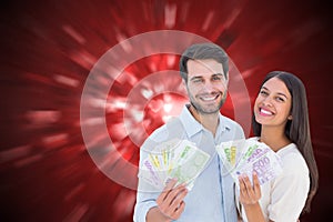 Composite image of happy couple showing their money