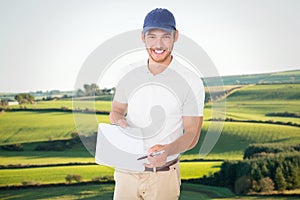 Composite image of happy delivery man holding clipboard