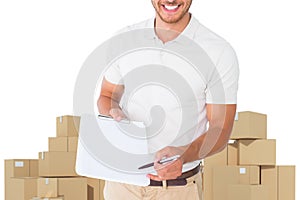 Composite image of happy delivery man holding clipboard