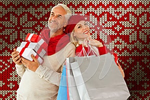 Composite image of happy festive couple with gifts and bags