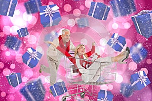 Composite image of happy festive couple messing in trolley