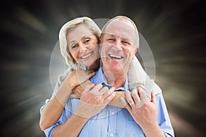 Composite image of happy mature couple embracing smiling at camera