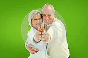 Composite image of happy mature couple showing thumbs up