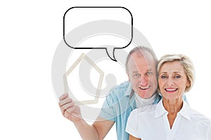 Composite image of happy older couple holding house shape