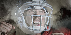 Composite image of happy sportsman cheering while looking up