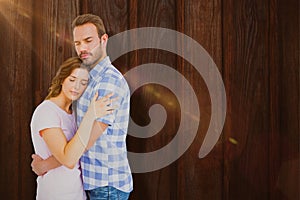 Composite image of happy young couple cuddling each other