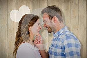 Composite image of happy young couple looking at each other and smiling