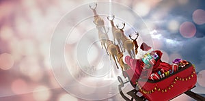 Composite image of high angle view of santa claus riding on sled with gift box