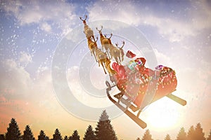 Composite image of high angle view of santa claus riding on sled with gift box