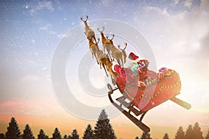 Composite image of high angle view of santa claus riding on sled with gift box