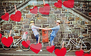 Composite image of hip young couple dancing by brick wall with their bikes