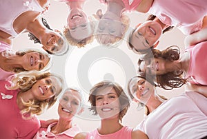 Composite image of low angle portrait of female friends supporting breast cancer