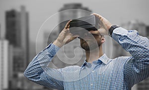 Composite image of low angle view of man using virtual reality glasses