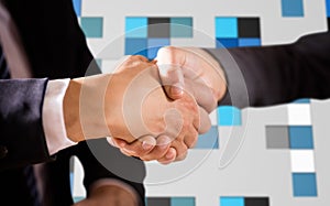 Composite image of male and female corporates shaking hands photo