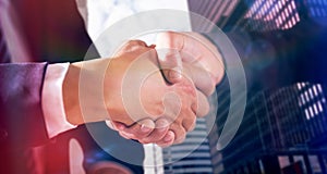 Composite image of male and female corporates shaking hands photo