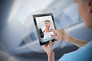 Composite image of male nurse using digital tablet