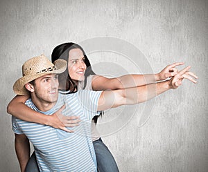 Composite image of man giving his pretty girlfriend a piggy back