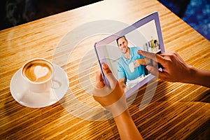 Composite image of man with newspaper holding coffee cup at table