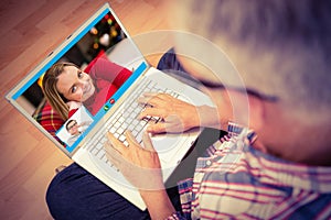Composite image of man using laptop while sitting on floor at home