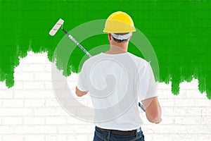 Composite image of man using paint roller