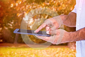 Composite image of a man using tablet computer